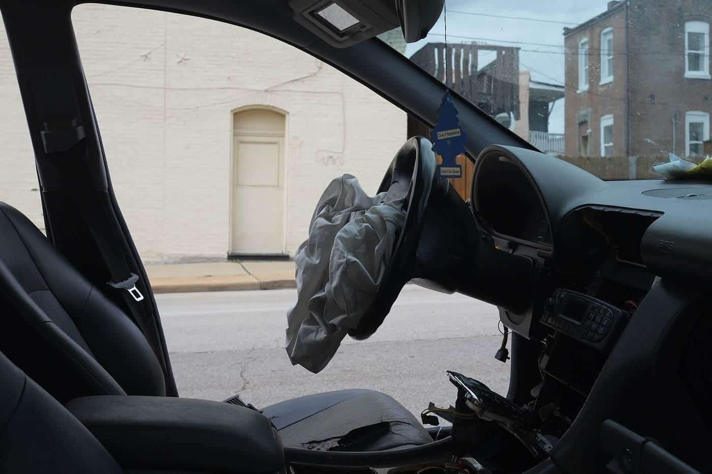 A deployed airbag hanging from a car steering wheel
