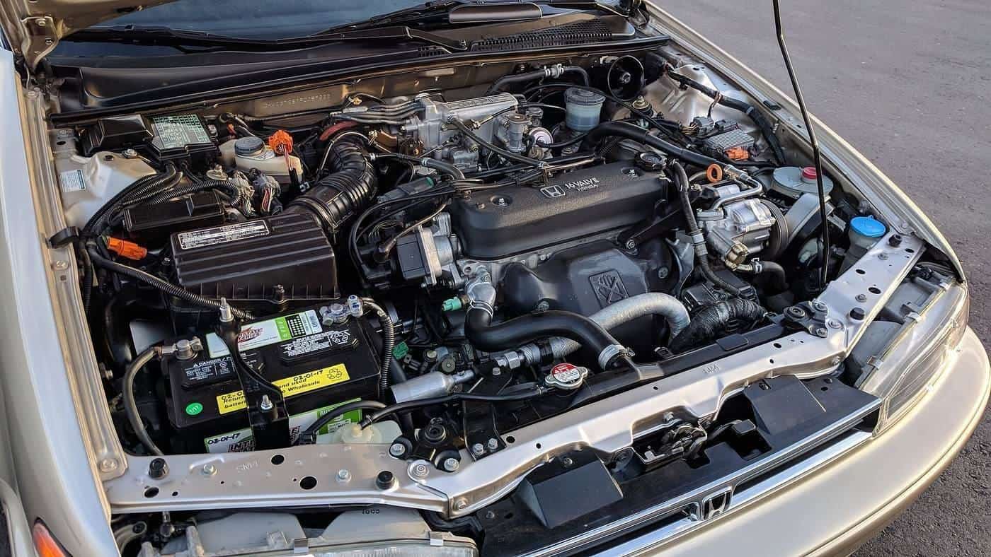 The engine bay of a 1990s sedan with the bonnet open